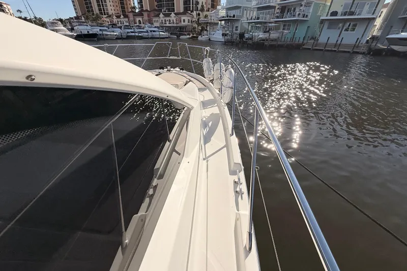 Slide: The Image of 2016 Cranchi M44 HT yacht docked, reflecting sunlight on water. - 146