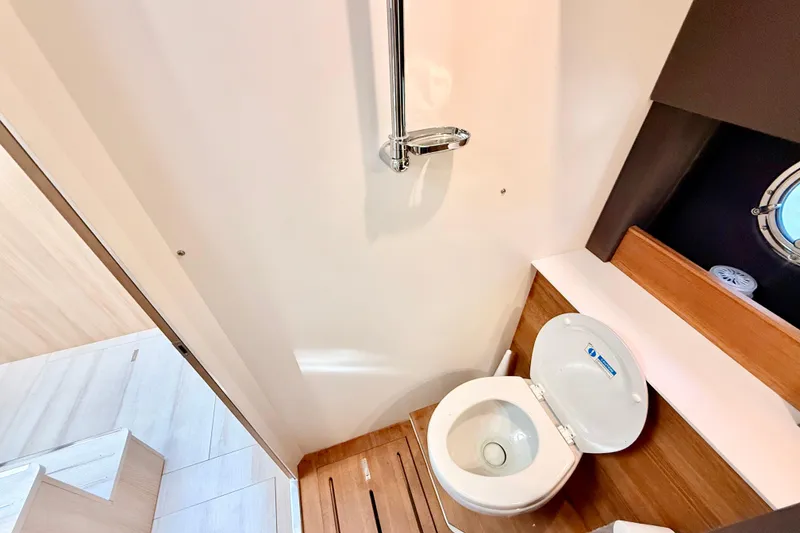 Slide: The Image of 2016 Cranchi M44 HT yacht bathroom with modern toilet and wooden accents. - 114