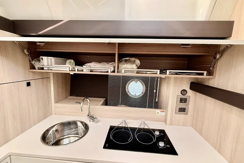 Slide: The Image of 2016 Cranchi M44 HT yacht kitchen with sink, stove, and storage cabinets. - 56