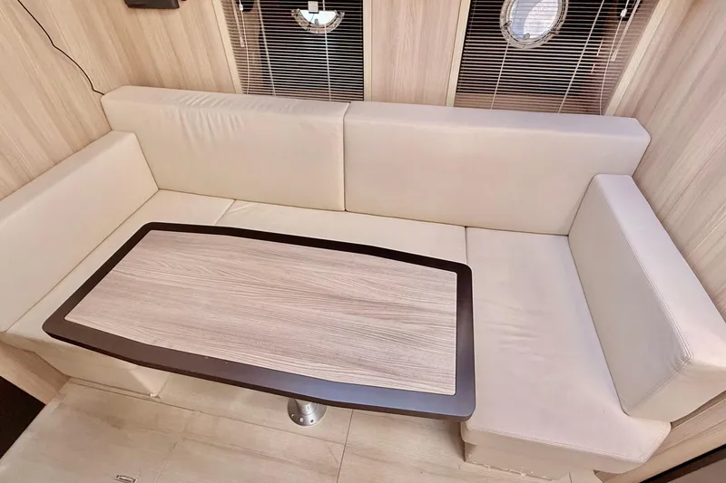 Slide: The Image of Luxurious interior of 2016 Cranchi M44 HT yacht with beige seating and wooden table. - 86