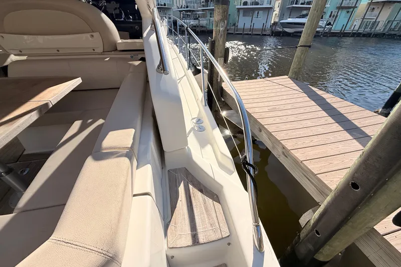 Slide: The Image of 2016 Cranchi M44 HT yacht interior with beige seating and wooden dock view. - 143