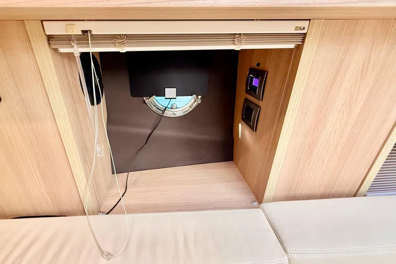 Slide: The Image of 2016 Cranchi M44 HT yacht interior with porthole, control panel, and wooden finish. - 90