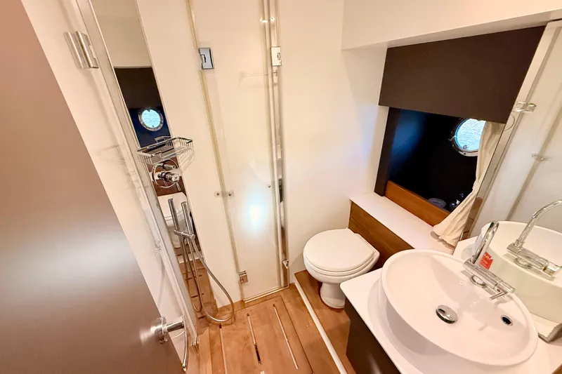 Slide: The Image of Modern bathroom in 2016 Cranchi M44 HT yacht with shower, sink, and porthole window. - 105