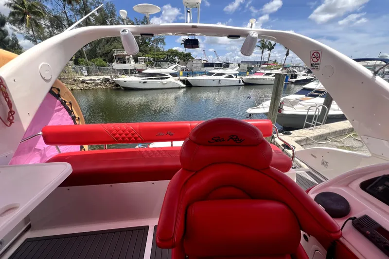 Slide: The Image of 2002 Sea Ray 450 Express Bridge with red seating, docked at a marina under a blue sky. - 40