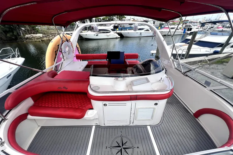 Slide: The Image of 2002 Sea Ray 450 Express Bridge with red seating, docked in a marina. - 13