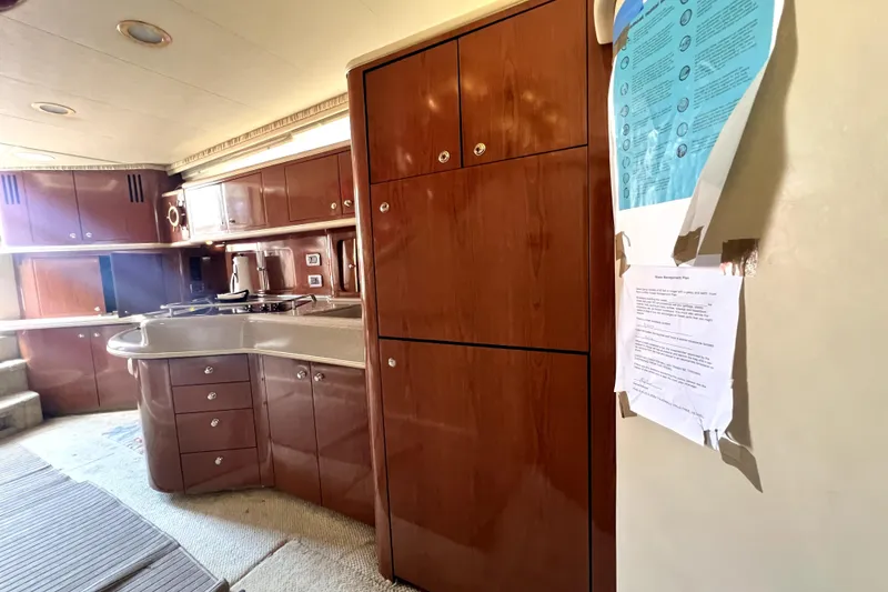 Slide: The Image of Interior of 2002 Sea Ray 450 Express Bridge yacht with wooden cabinetry and kitchen area. - 27
