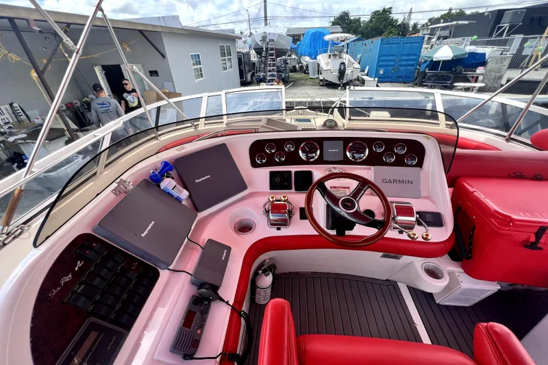 Slide: The Image of 2002 Sea Ray 450 Express Bridge helm with red seating, Garmin navigation, and Raymarine equipment. - 20