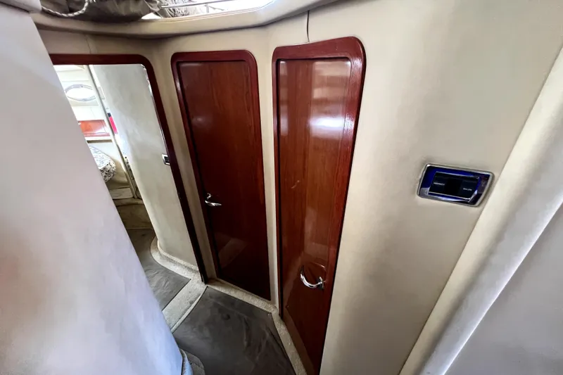 Slide: The Image of Interior view of 2002 Sea Ray 450 Express Bridge with wooden doors and control panel. - 31