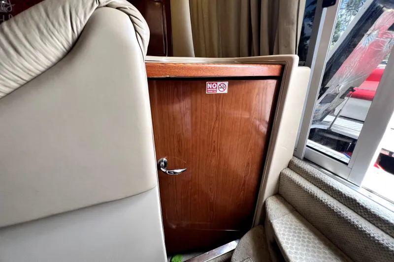 Slide: The Image of Interior view of 2002 Sea Ray 450 Express Bridge with wooden door and stairs. - 22