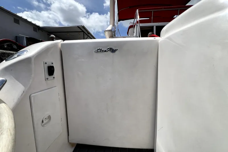 Slide: The Image of 2002 Sea Ray 450 Express Bridge yacht entrance with logo, under a partly cloudy sky. - 15