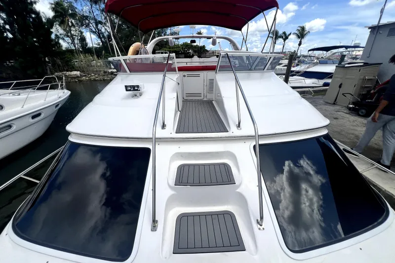 Slide: The Image of 2002 Sea Ray 450 Express Bridge yacht with red canopy, docked at marina. - 45