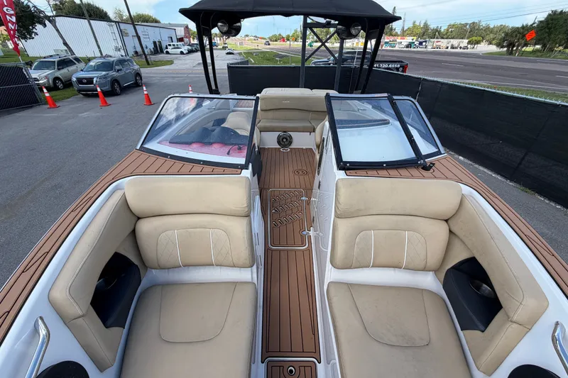 Slide: The Image of 2016 Glastron GT 245 boat interior with beige seating and wood-style flooring. - 58