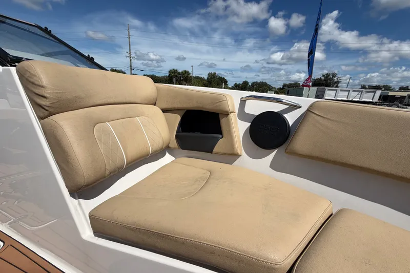 Slide: The Image of 2016 Glastron GT 245 boat interior with beige seating under a blue sky. - 50