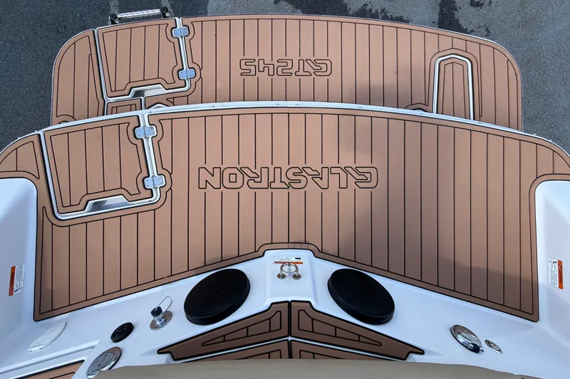 Slide: The Image of 2016 Glastron GT 245 boat deck with custom brown flooring and logo. - 79