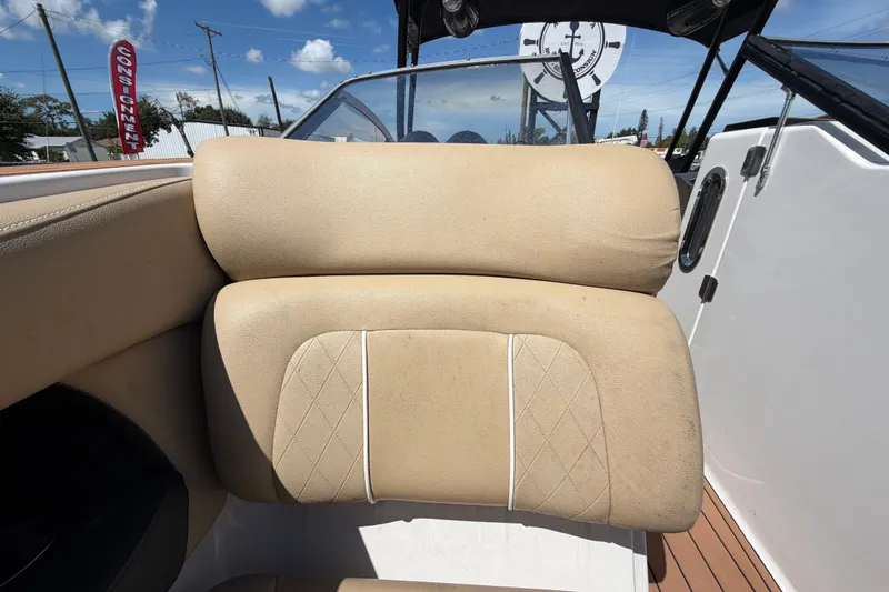 Slide: The Image of Beige seating on 2016 Glastron GT 245 boat, with clear skies and consignment sign. - 52