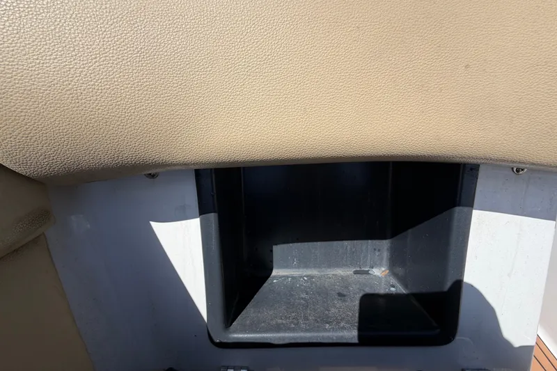 Slide: The Image of Storage compartment in a 2016 Glastron GT 245 boat, featuring beige upholstery. - 53