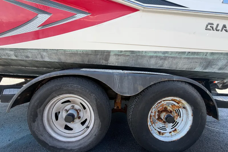 Slide: The Image of Trailer with Glastron GT 245 boat, 2016 model, showing wheels and hull details. - 85