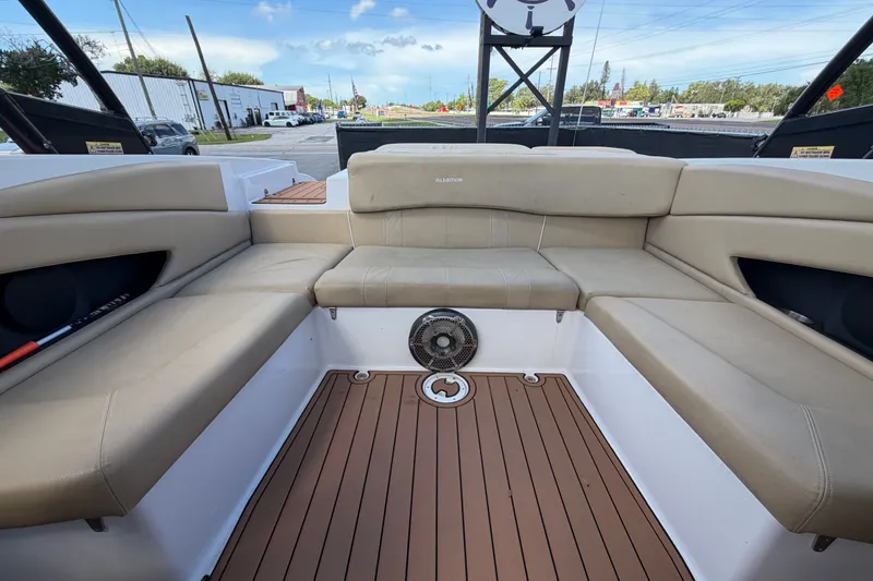 Slide: The Image of 2016 Glastron GT 245 boat interior with beige seating and wood-style flooring. - 61