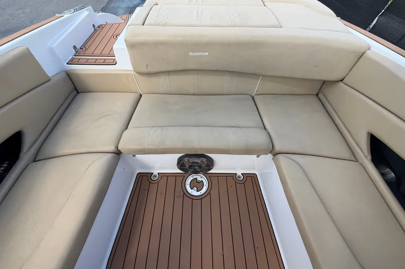 Slide: The Image of 2016 Glastron GT 245 boat interior with beige seating and wood-style flooring. - 62