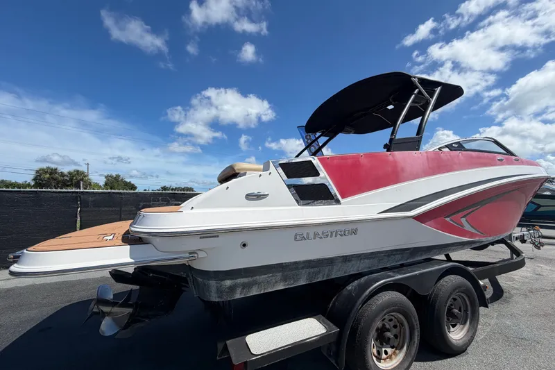 Slide: The Image of 2016 Glastron GT 245 boat on trailer under blue sky. - 2
