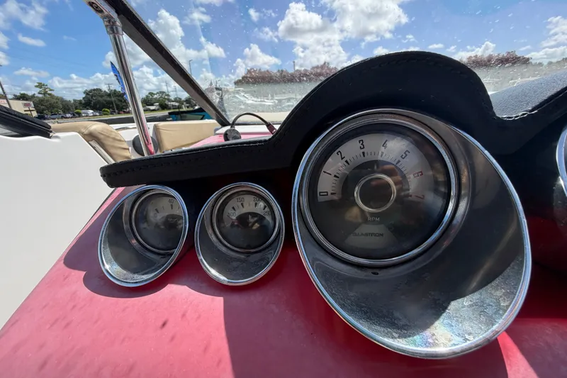 Slide: The Image of Dashboard gauges of a 2016 Glastron GT 245 boat under a sunny sky. - 25