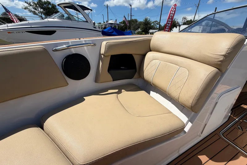 Slide: The Image of 2016 Glastron GT 245 boat interior with beige seating and speaker detail. - 54