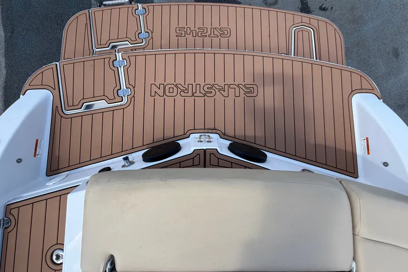 Slide: The Image of 2016 Glastron GT 245 boat deck with brown non-slip surface and beige seating. - 78