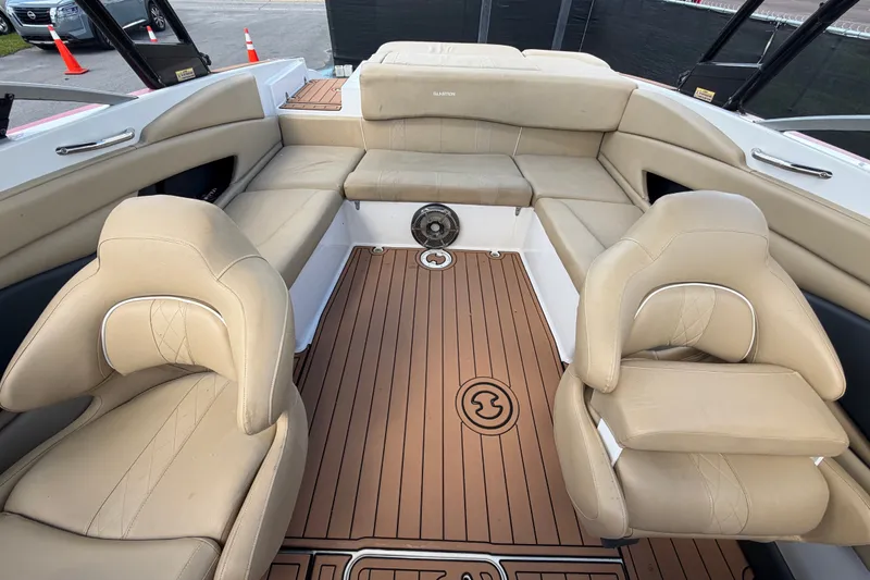 Slide: The Image of 2016 Glastron GT 245 boat interior with beige seating and wood-style flooring. - 60