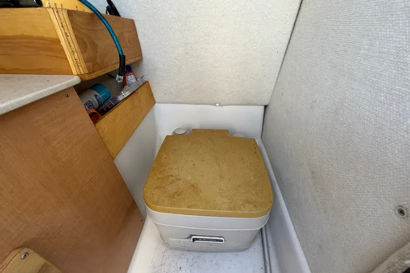 Slide: The Image of Compact boat cabin toilet in 2016 Glastron GT 245, with wooden storage shelves. - 35