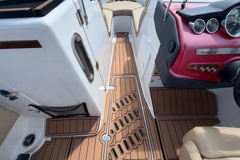 Slide: The Image of Interior of 2016 Glastron GT 245 boat with wood-style flooring and modern dashboard. - 36