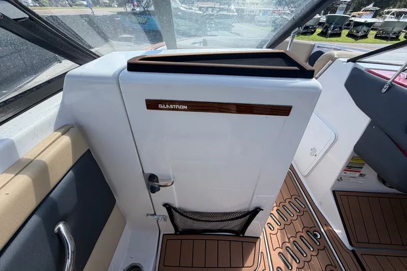 Slide: The Image of 2016 Glastron GT 245 boat interior with wood accents and seating. - 31