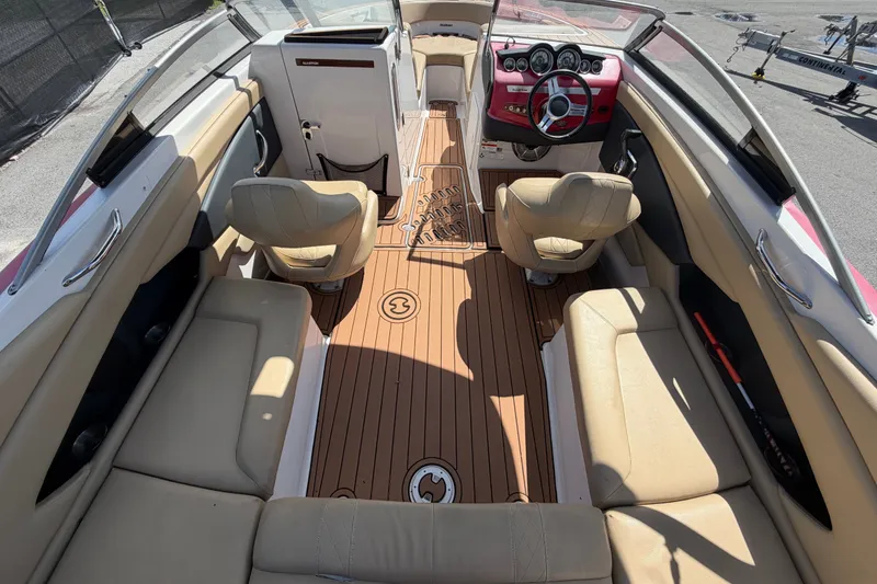 Slide: The Image of 2016 Glastron GT 245 boat interior with beige seating and wood-style flooring. - 19