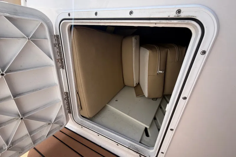 Slide: The Image of Storage compartment on a 2016 Glastron GT 245 boat with beige cushions. - 39
