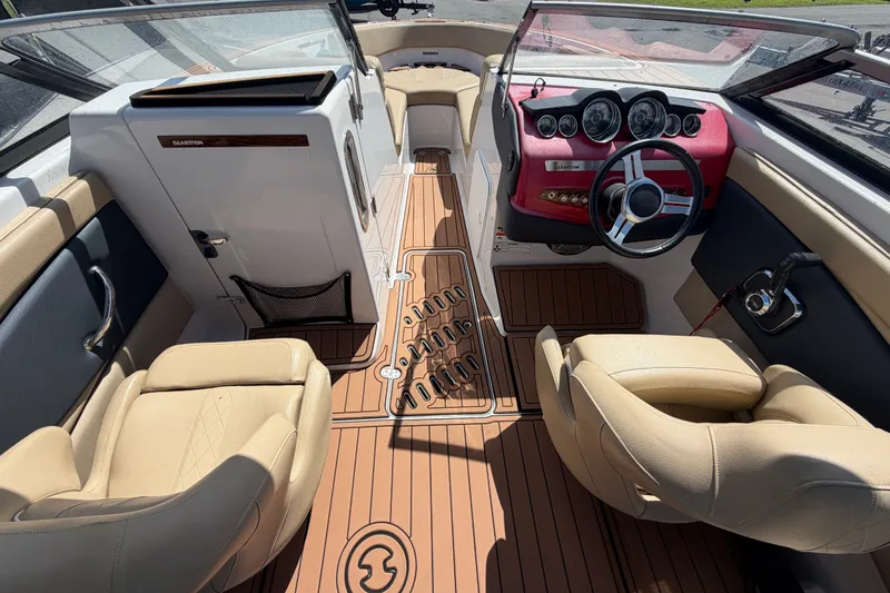 Slide: The Image of Interior of a 2016 Glastron GT 245 boat with beige seating and wooden flooring. - 21