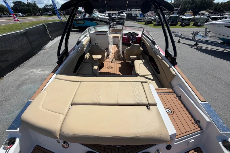Slide: The Image of 2016 Glastron GT 245 boat interior with beige seating and wood accents. - 14