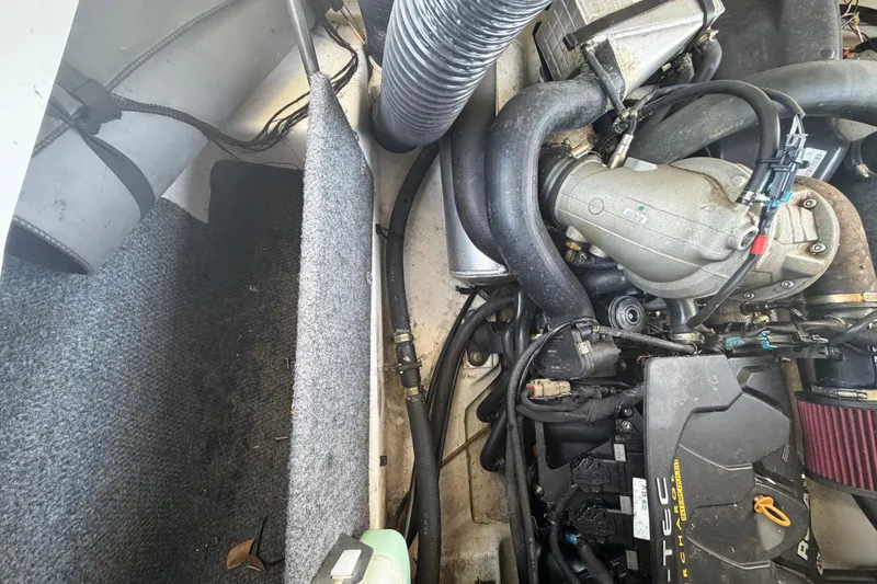 Slide: The Image of Engine compartment of a 2016 Scarab 165 boat, showcasing mechanical components and hoses. - 47