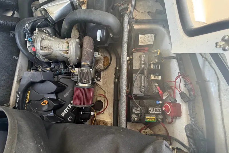Slide: The Image of Engine compartment of a 2016 Scarab 165 boat, featuring Rotax engine and battery setup. - 49