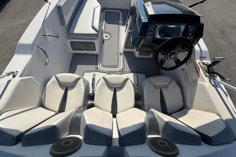 Slide: The Image of De afbeelding toont de cockpit van een Scarab 165 boot uit 2016 met witte stoelen en een zwart stuurwiel. - 17