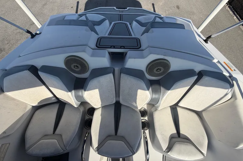 Slide: The Image of The image shows the cockpit of a 2016 Scarab 165 boat with gray upholstery and speakers. - 44
