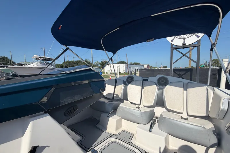 Slide: The Image of 2016 Scarab 165 boat interior with seating and canopy, docked under clear blue sky. - 39