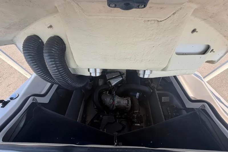 Slide: The Image of Engine compartment of a 2016 Scarab 165 boat, showcasing internal components and ventilation hoses. - 46