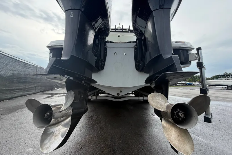 Slide: The Image of Rear view of 2001 Baja 340 Islander Outboard with dual propellers on wet pavement. - 4
