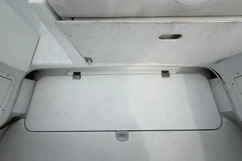 Slide: The Image of 2001 Baja 340 Islander Outboard interior, featuring white storage compartments and seating. - 61