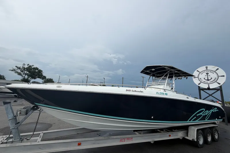 Slide: The Image of 2001 Baja 340 Islander Outboard boat on trailer, displayed outdoors under cloudy sky. - 11