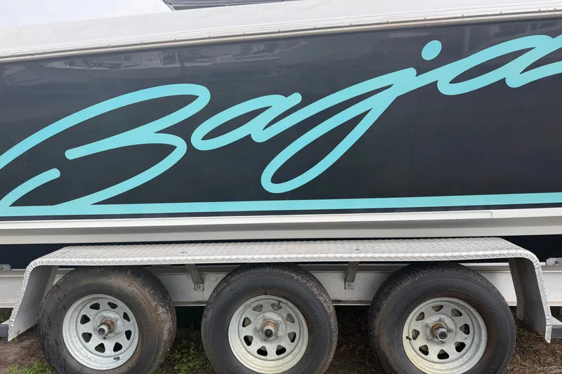 Slide: The Image of 2001 Baja 340 Islander Outboard boat on trailer, featuring bold branding. - 79