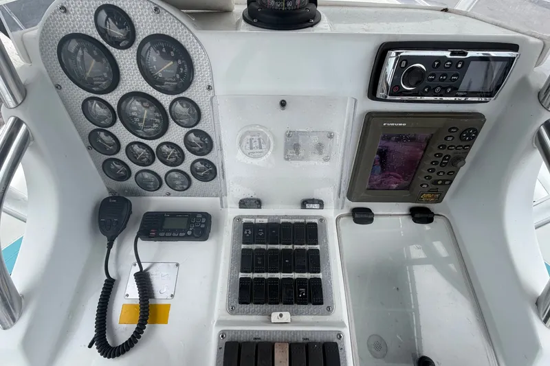 Slide: The Image of Control panel of a 2001 Baja 340 Islander Outboard with gauges, radio, and navigation equipment. - 26