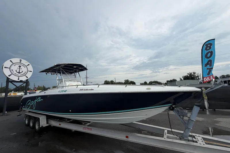 The Image of 2001 Baja 340 Islander Outboard boat on trailer at a sales lot under cloudy sky. - 0