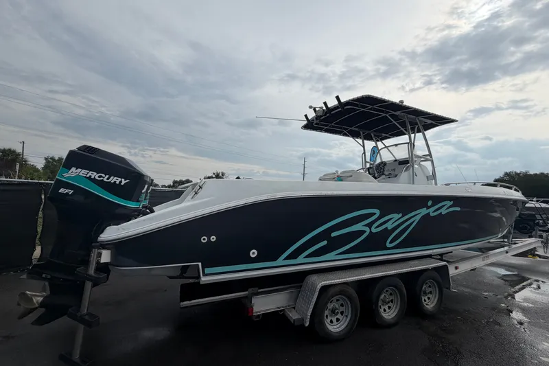 Slide: The Image of 2001 Baja 340 Islander Outboard boat on trailer with Mercury engine, under cloudy sky. - 2