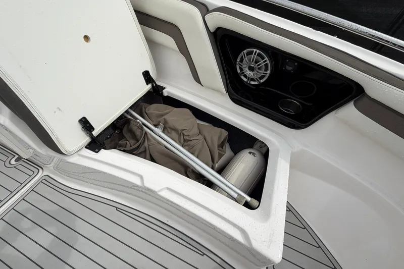 Slide: The Image of Open storage compartment on 2016 Yamaha Boats 242 Limited S E-Series, showing equipment and speaker. - 36