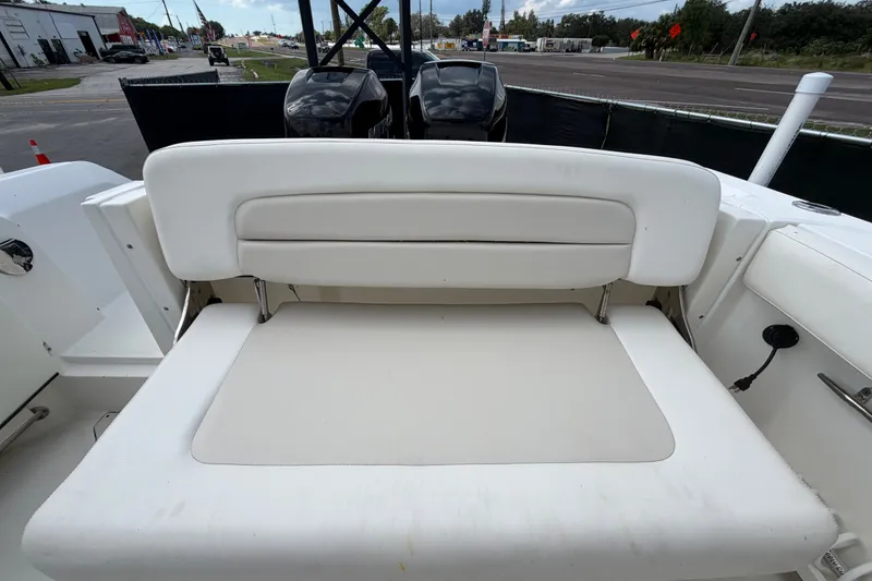 Slide: The Image of 2015 Boston Whaler 270 Vantage boat with white cushioned seating and dual outboard motors. - 73